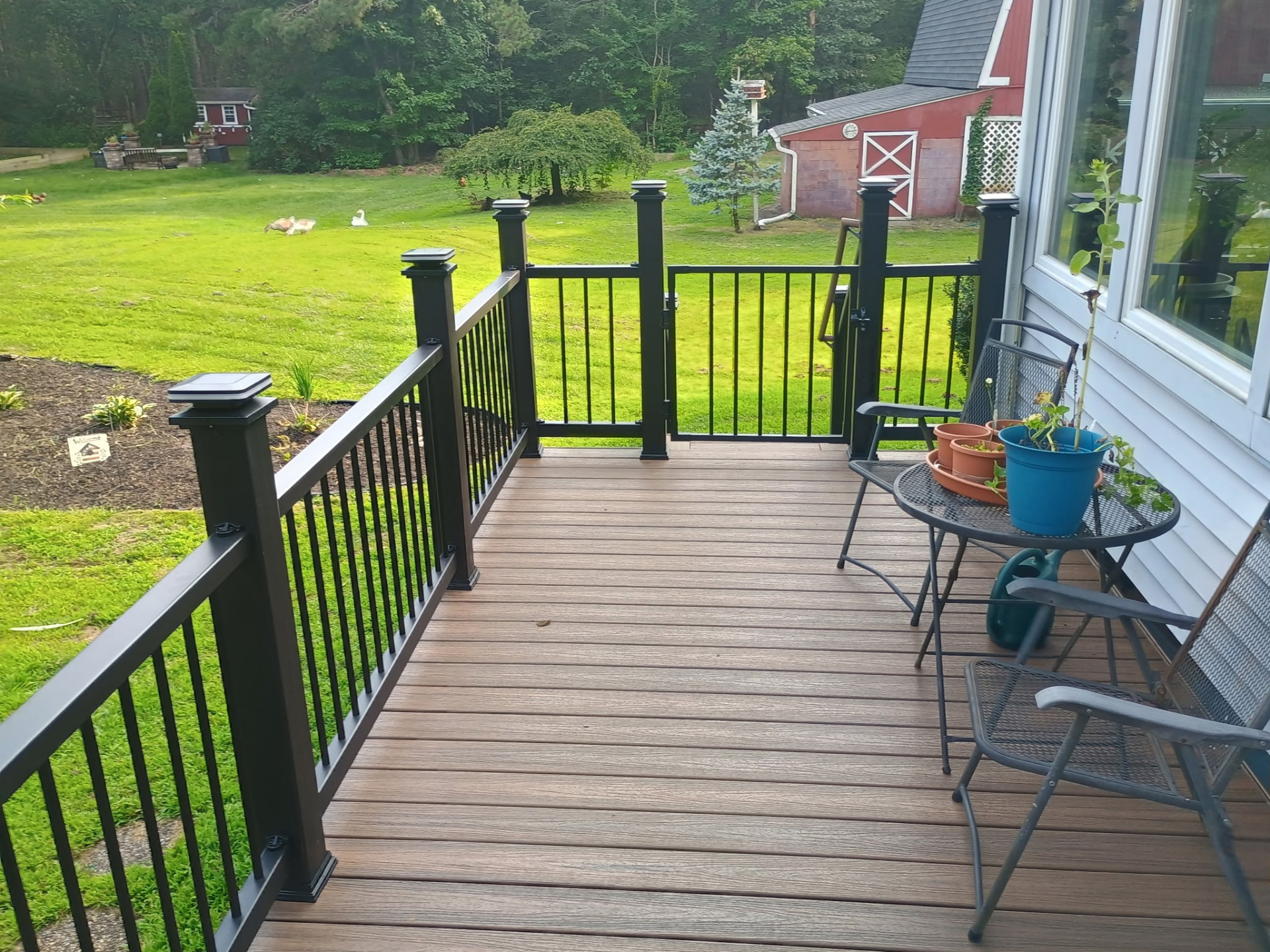 Finished composite deck overlooking backyard with red barn